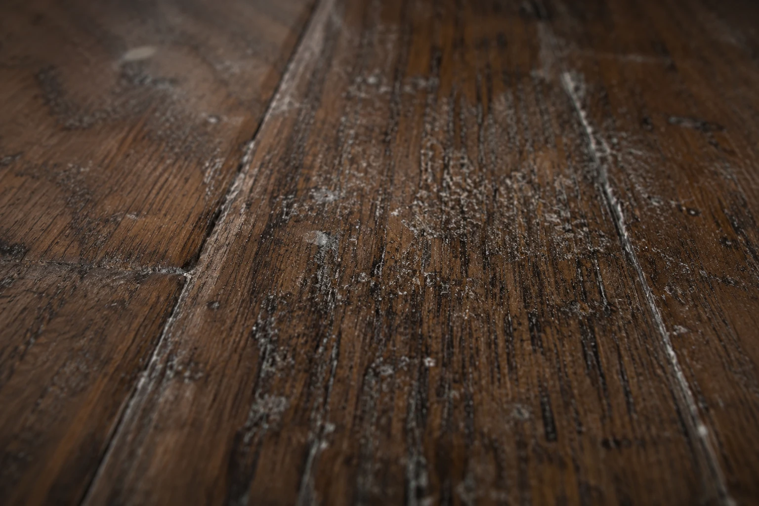 Hardwood floor grain with dull residue and embedded grime before professional cleaning